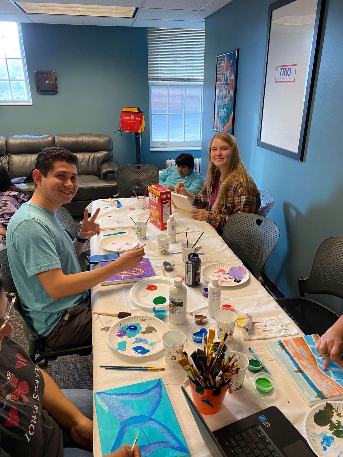 A group of students painting at a Trio event